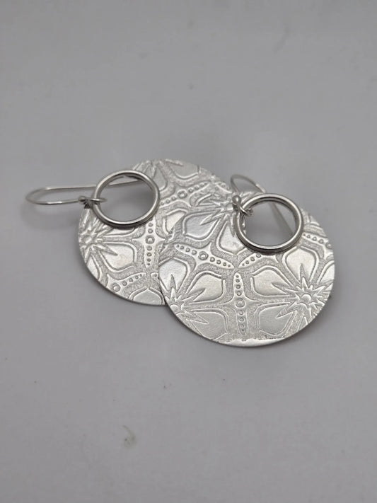 Blue Teapot Jewelry sterling silver circular drop earrings with an intricate floral embossed pattern and hoop connector