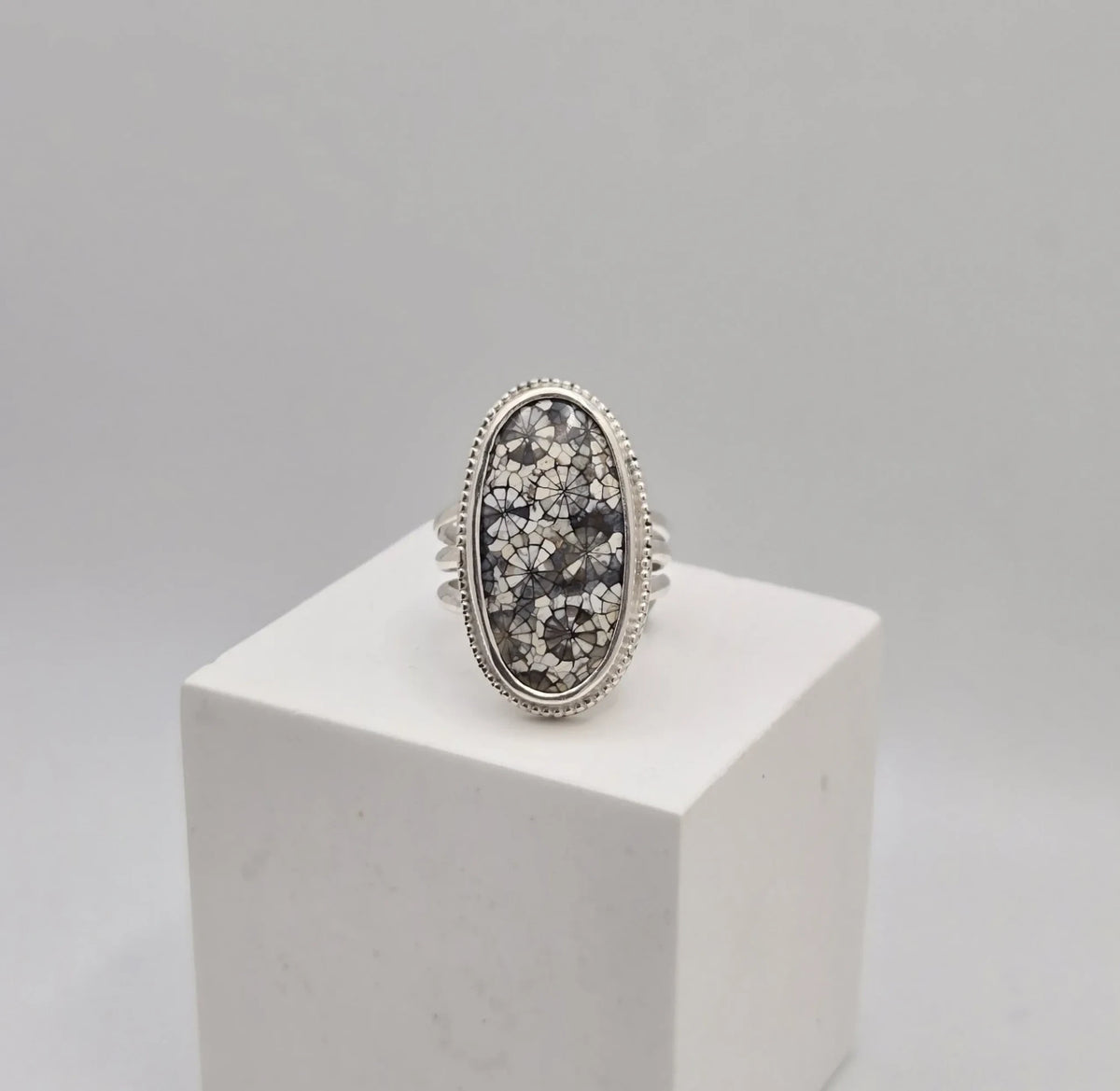 Blue Teapot Jewelry oval statement ring featuring fossil coral inlay in sterling silver with beaded edge detail.