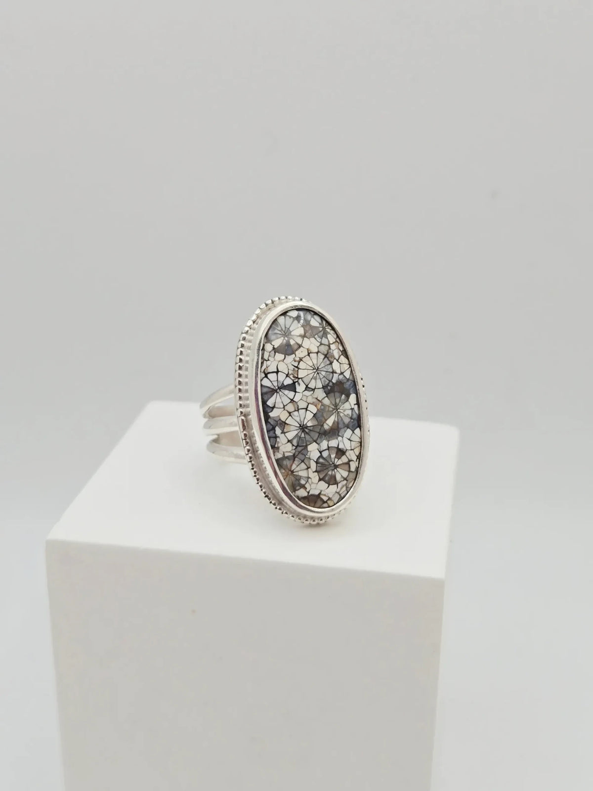 Blue Teapot Jewelry oval statement ring featuring a fossil coral inlay in grey and white with a beaded sterling silver bezel.